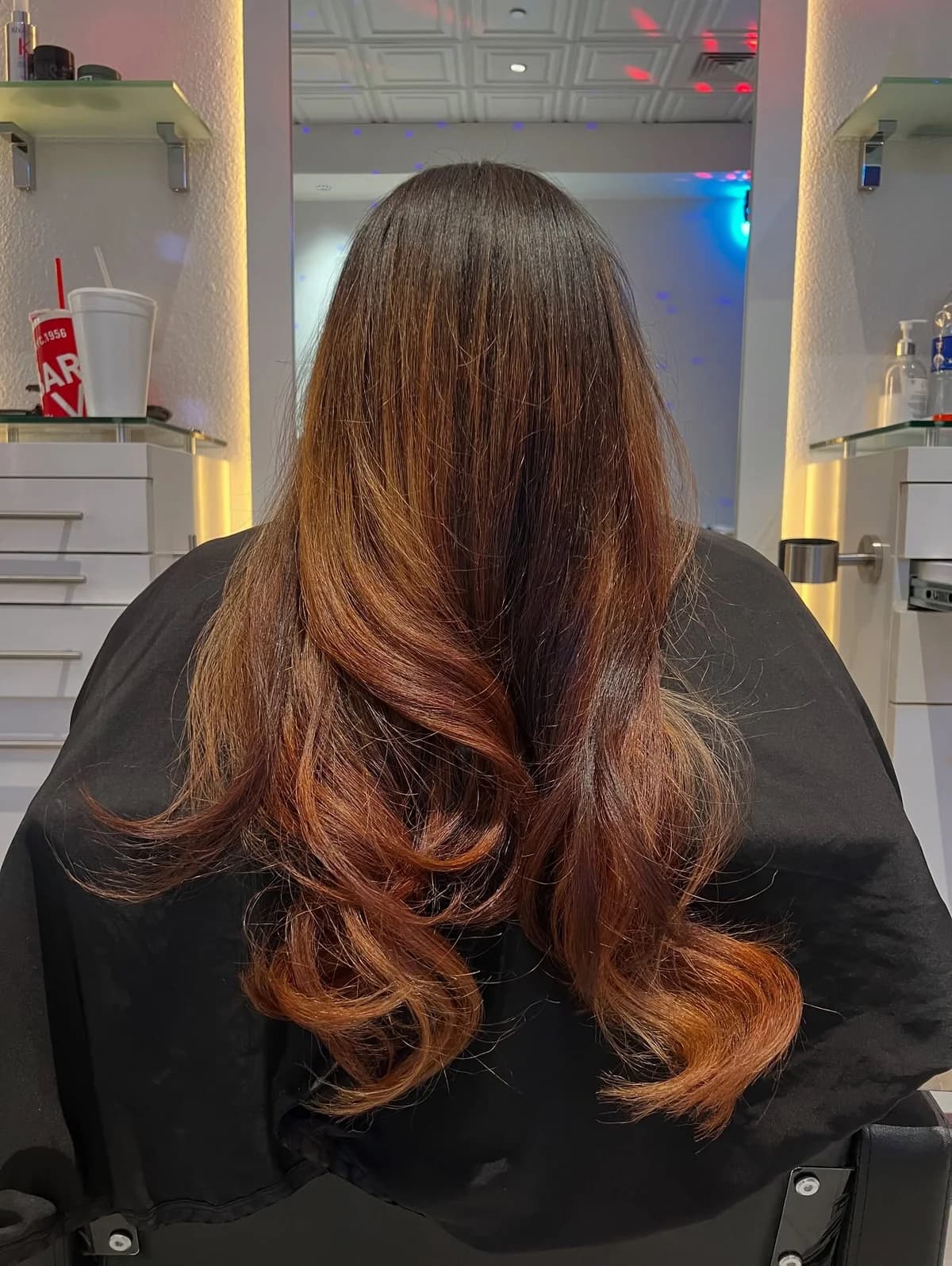 Dark-to-light balayage with warm brown and copper-toned lengths, viewed from behind