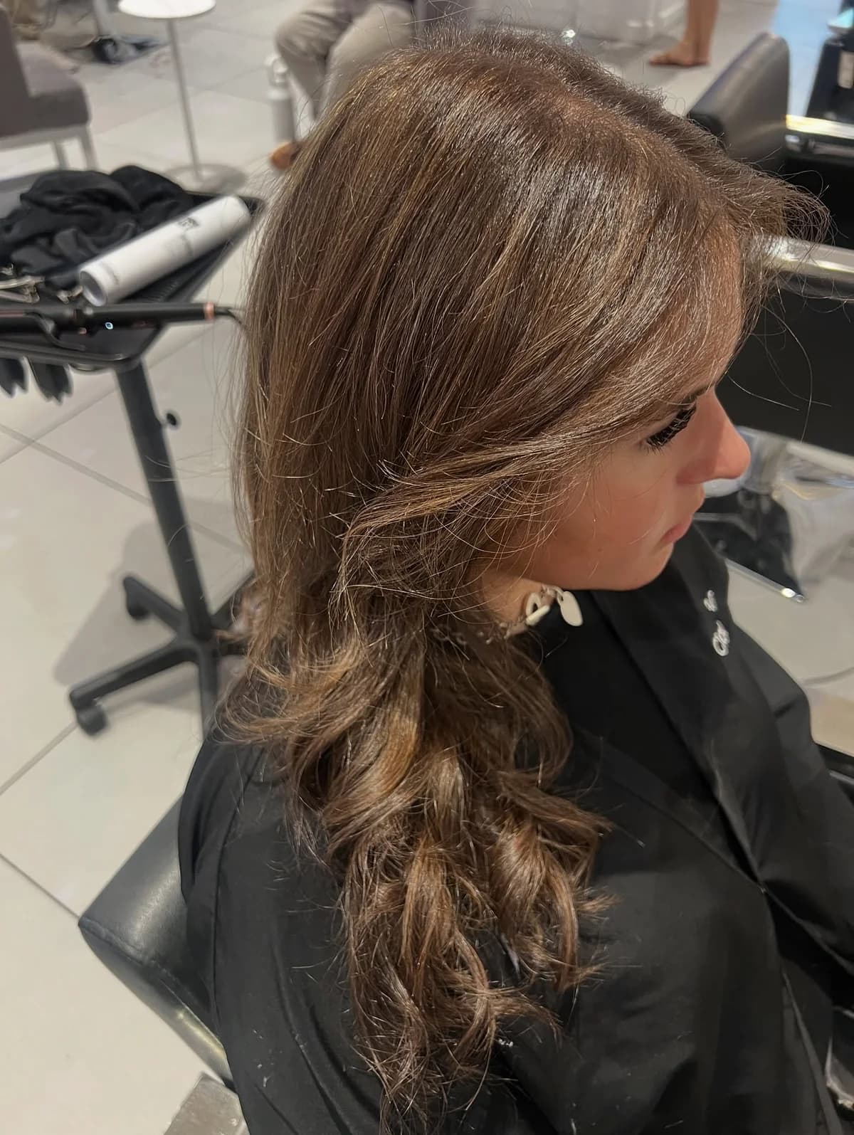 Natural brown balayage with warm dimension, viewed from the side in the salon