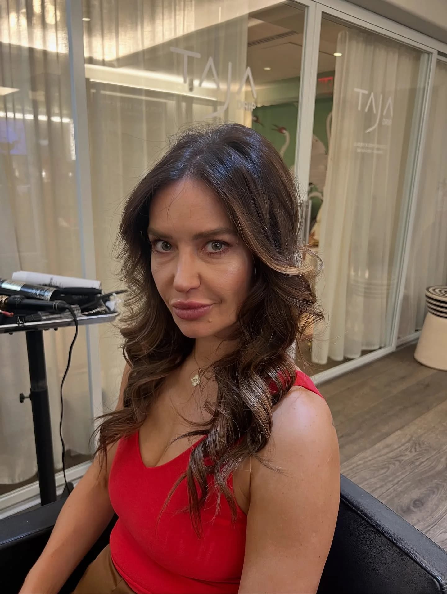 Woman in red with a brunette blowout and face-framing waves
