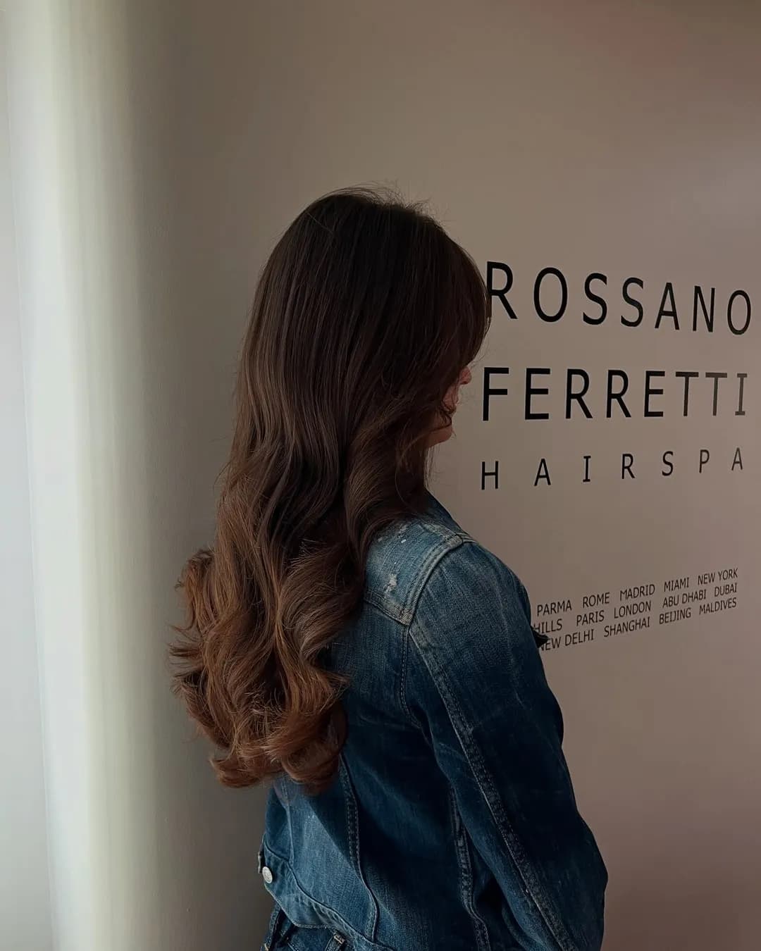 Long brunette layers with soft waves at the ends, seen from behind