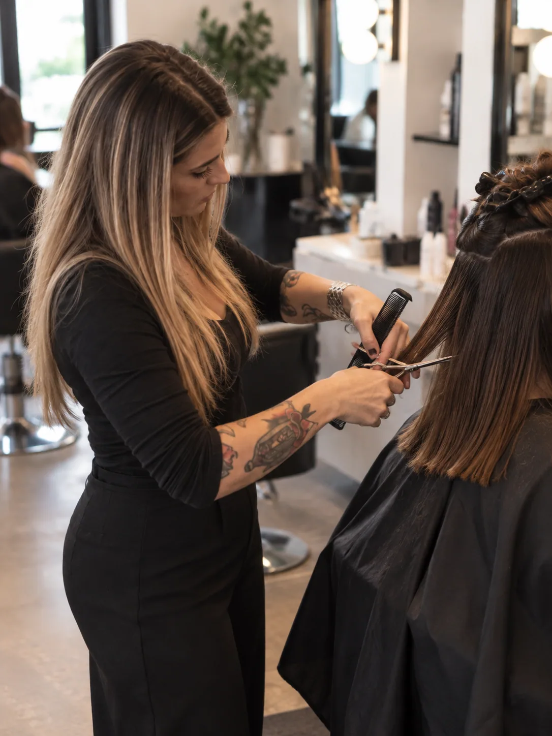 Hair stylist cutting a client's hair with scissors in a modern salon