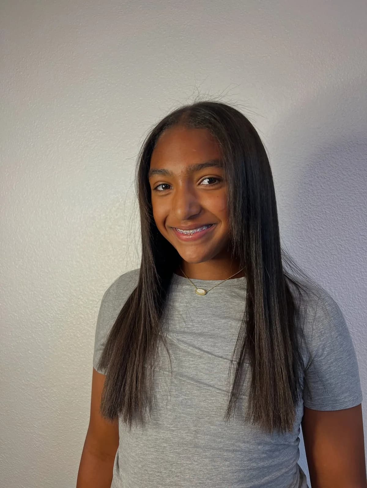 Client with long, straight dark hair after a keratin treatment, photographed from the front