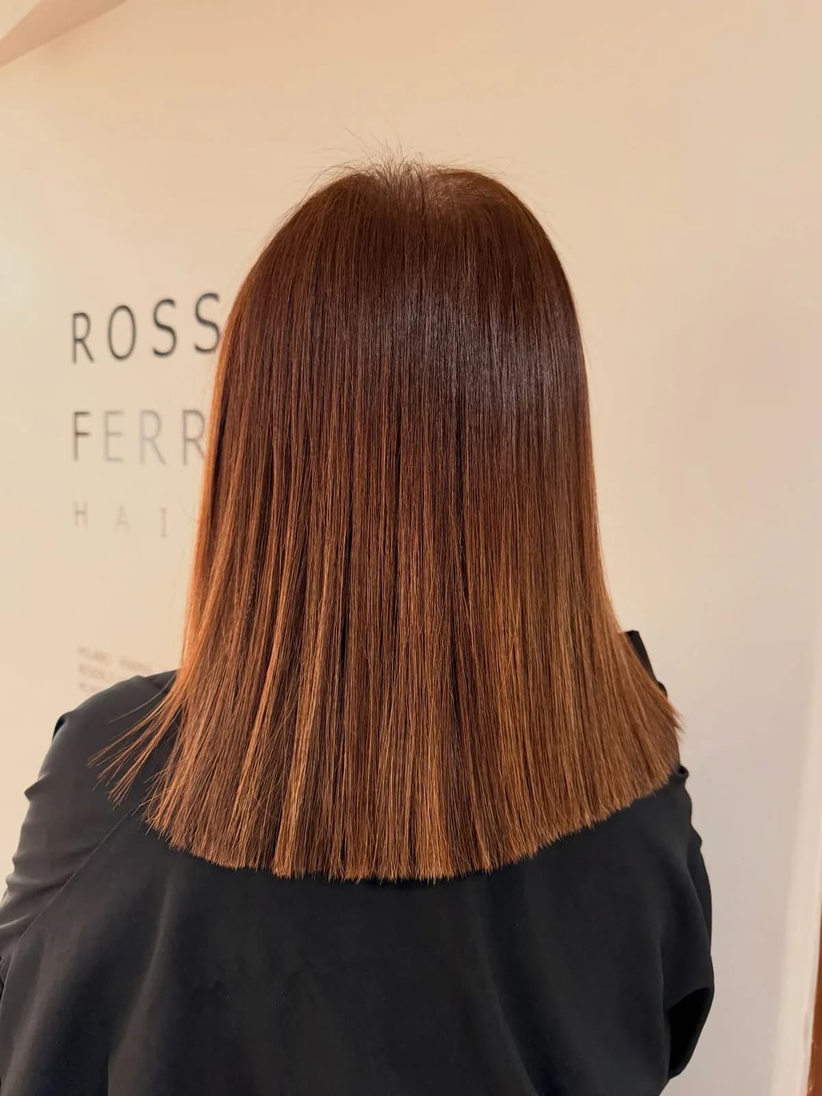 Straight auburn hair with even ends, photographed from behind